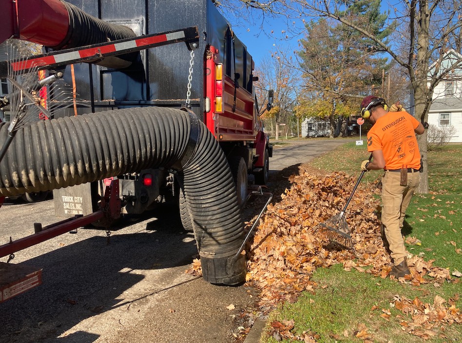 worker cleaning up leaves with vacuum truck
