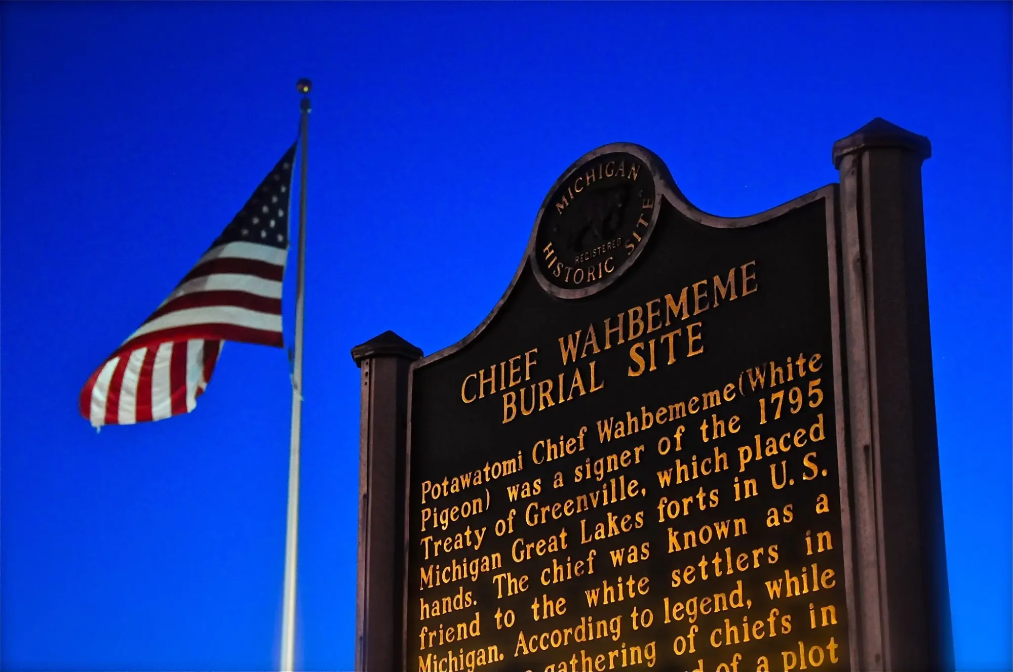 Chief Wahbememe Historical Sign with American Flag in the background